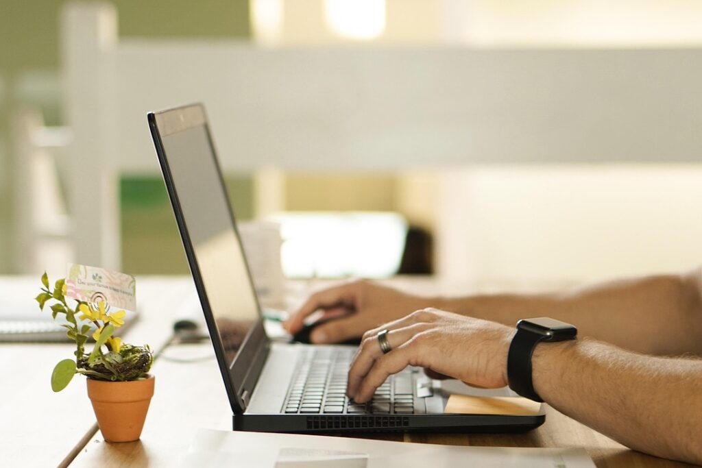 Persoon boekt online een afspraak bij de podoloog in Brugge of Ruddervoorde via laptop, met focus op de eerste afspraak.