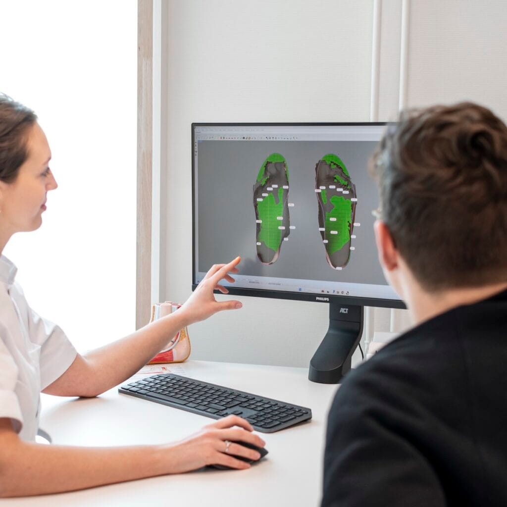 Voetanalyse in Brugge 3 Margaux Verstraete bespreekt de 3D-voetscan met een patiënt