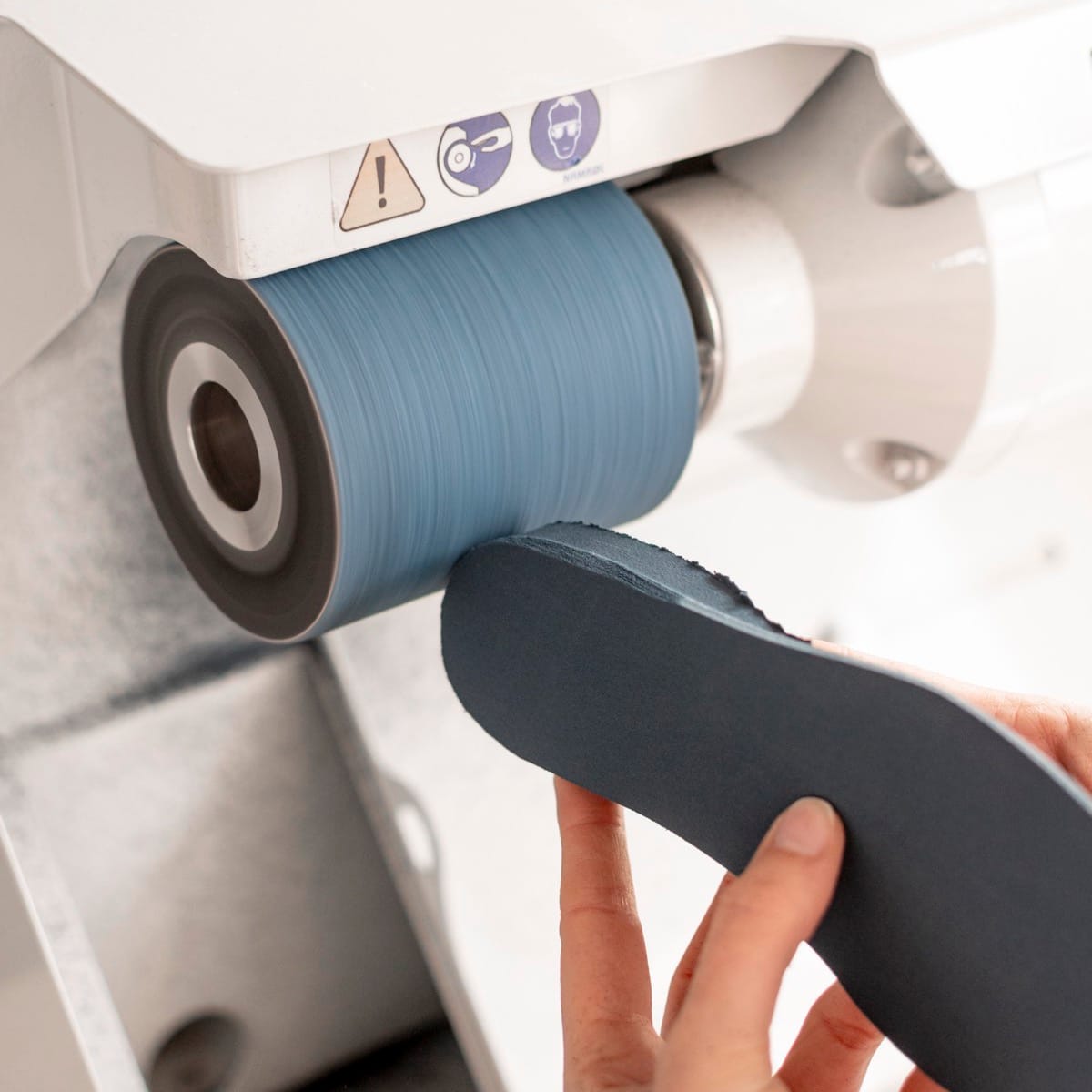 Hoe worden podologische zolen gemaakt? 4 Podoloog werkt een podologische zool af op de slijpmachine