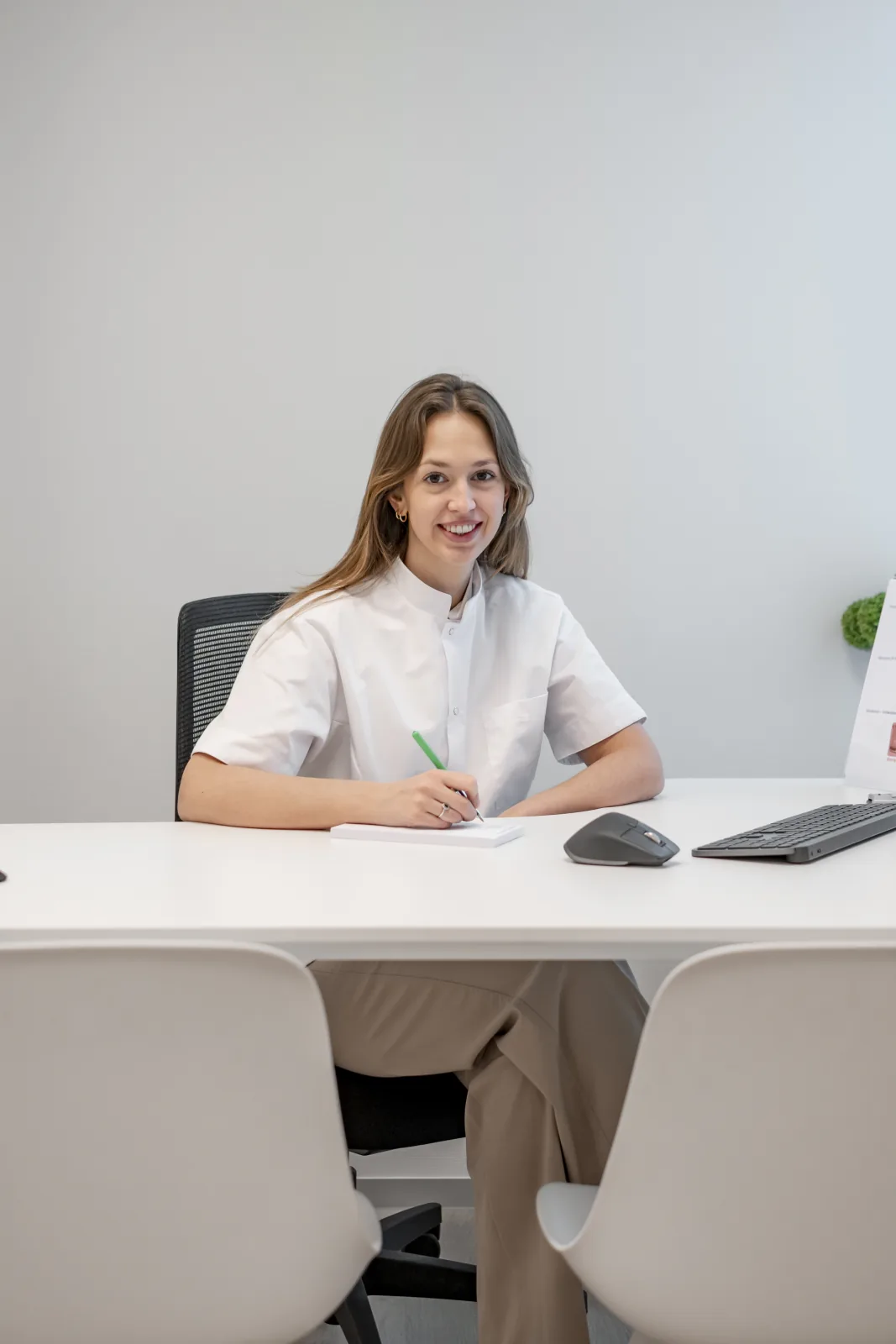 Podologie voor bedrijven 3 Margaux Verstraete, podoloog, aan haar bureau in de praktijk